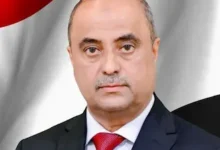 الصورة الرسمية لرئيس الوزراء اليمني سالم صالح بن بريك وخلفه العلم اليمني