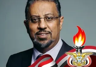 الدكتور ايوب الحمادي ويظهر في اسفل الصورة العلم اليمني