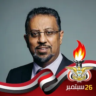 الدكتور ايوب الحمادي ويظهر في اسفل الصورة العلم اليمني
